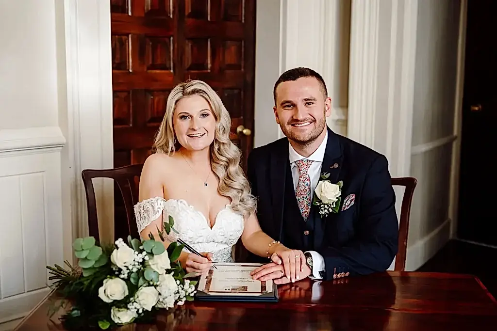bride and groom signing register in this 5 star review