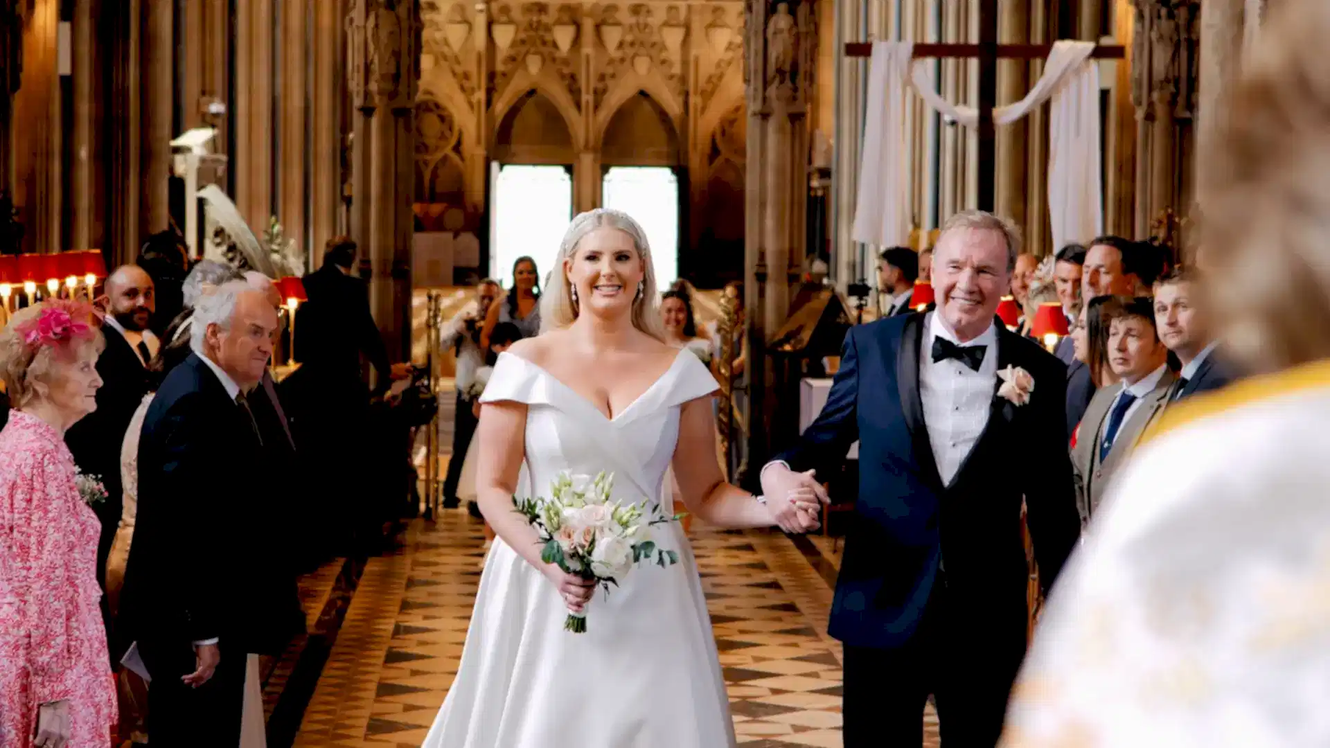 bride walks down aisle of bristol cathedral with her father in this example of a bristol wedding videographer and photographer at work