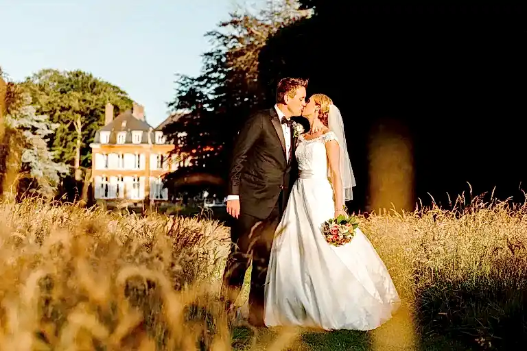 a man and woman kissing in front of a building as they pose for their destination wedding photographer