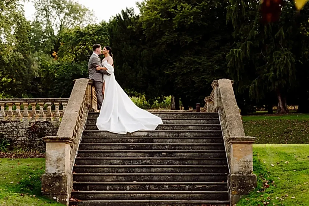 bride-groom-stood-coombe-lodge-steps bride and groom kiss on stone steps at coombe lodge wedding venue in somerset