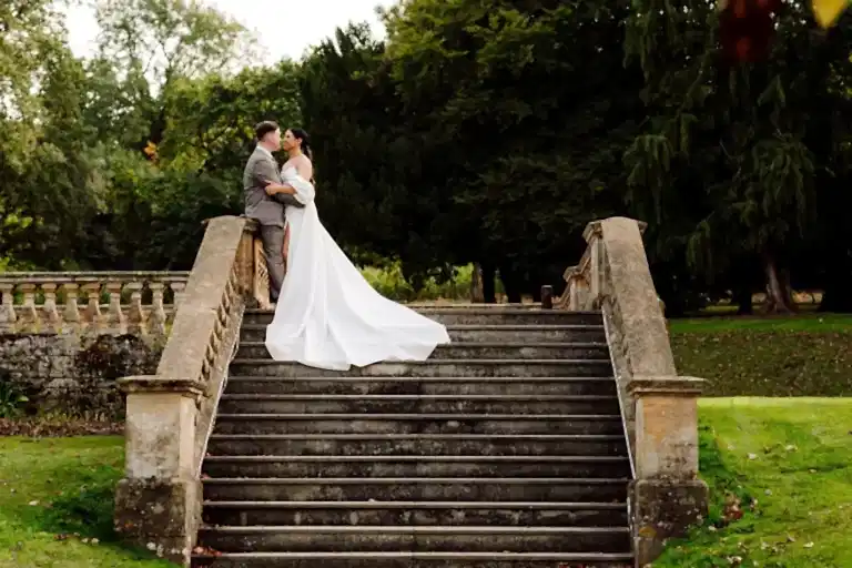 bride and groom kiss on stone steps at coombe lodge wedding venue in somerset