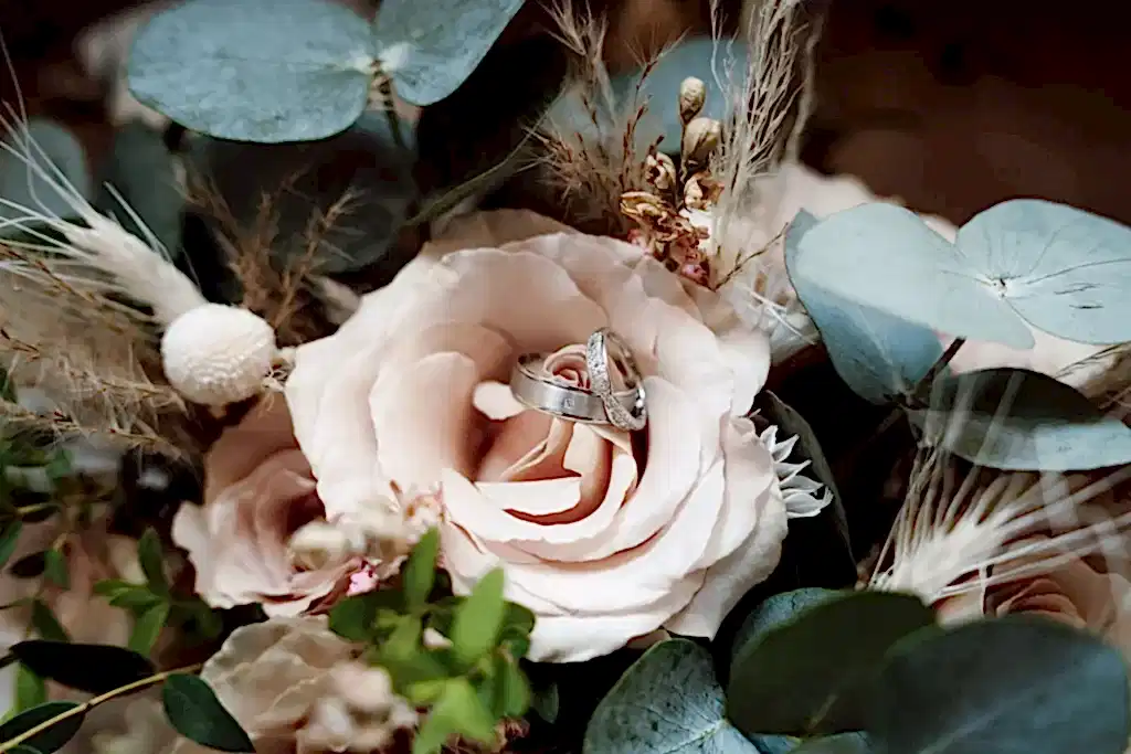 BUT0623-LOWRES-0022 wedding rings placed inside pale pink rose