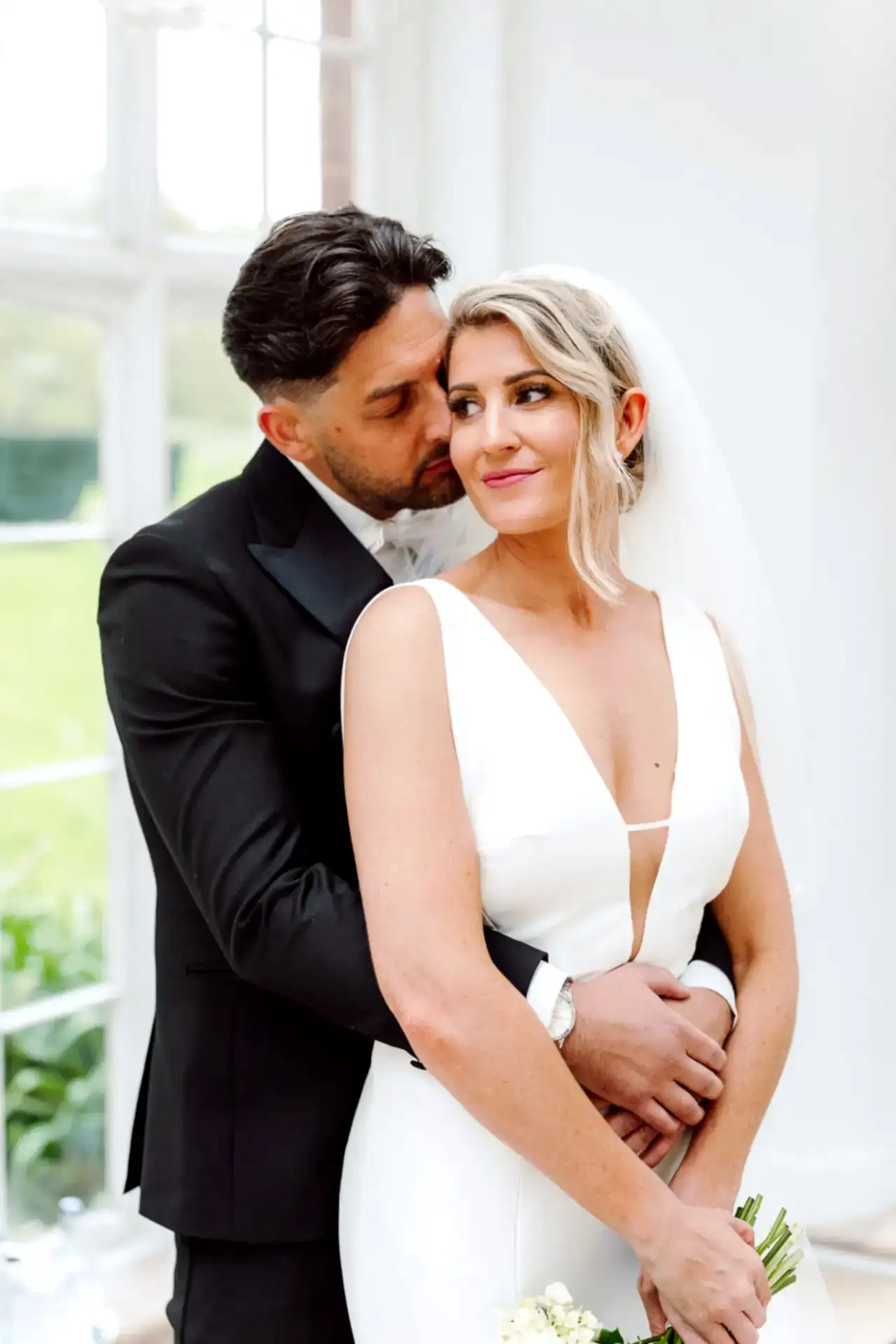 couple pose in a romantic embrace for their wedding photography shoot on their wedding day