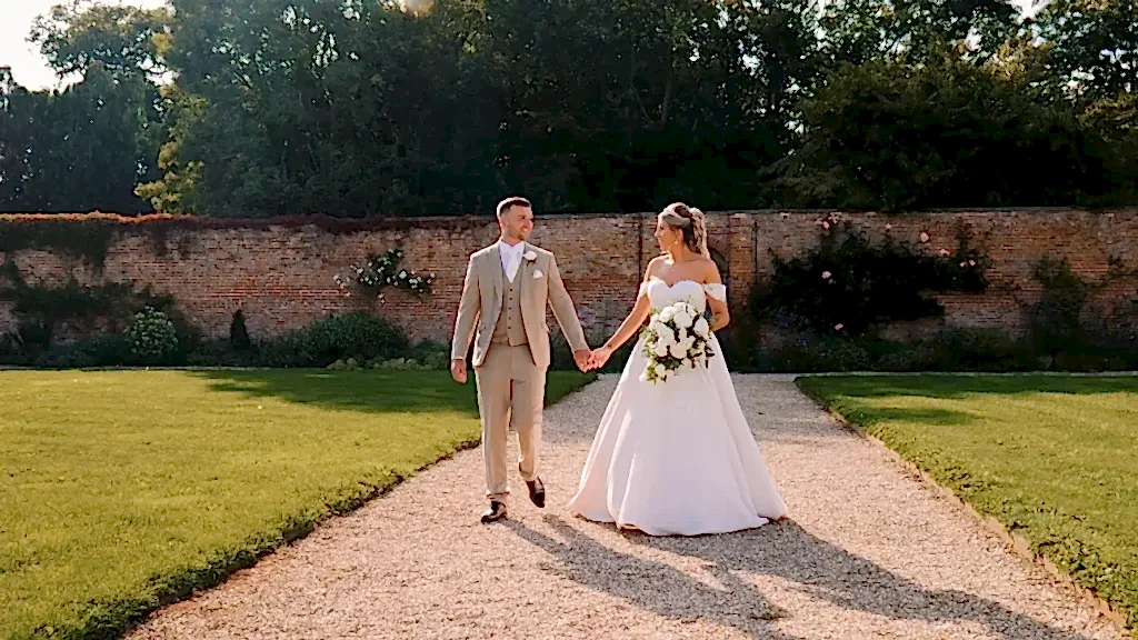 bride and groom holding hands in the walled garden at Elmhay Park in Orchardleigh wedding venue
