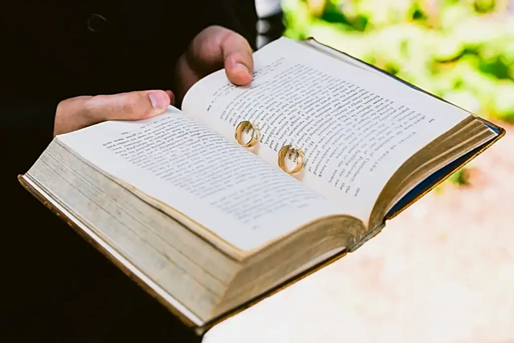 LOV0722-LOWRES-WEBSITE-0030 an open book holding two gold wedding rings in the page split
