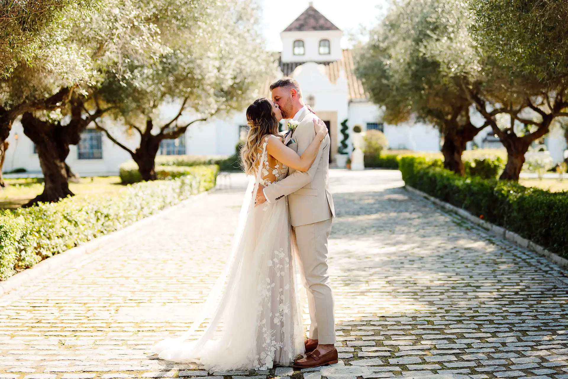 a bride and groom kissing on a brick path in Spain on their wedding day at the Finca Monasterio