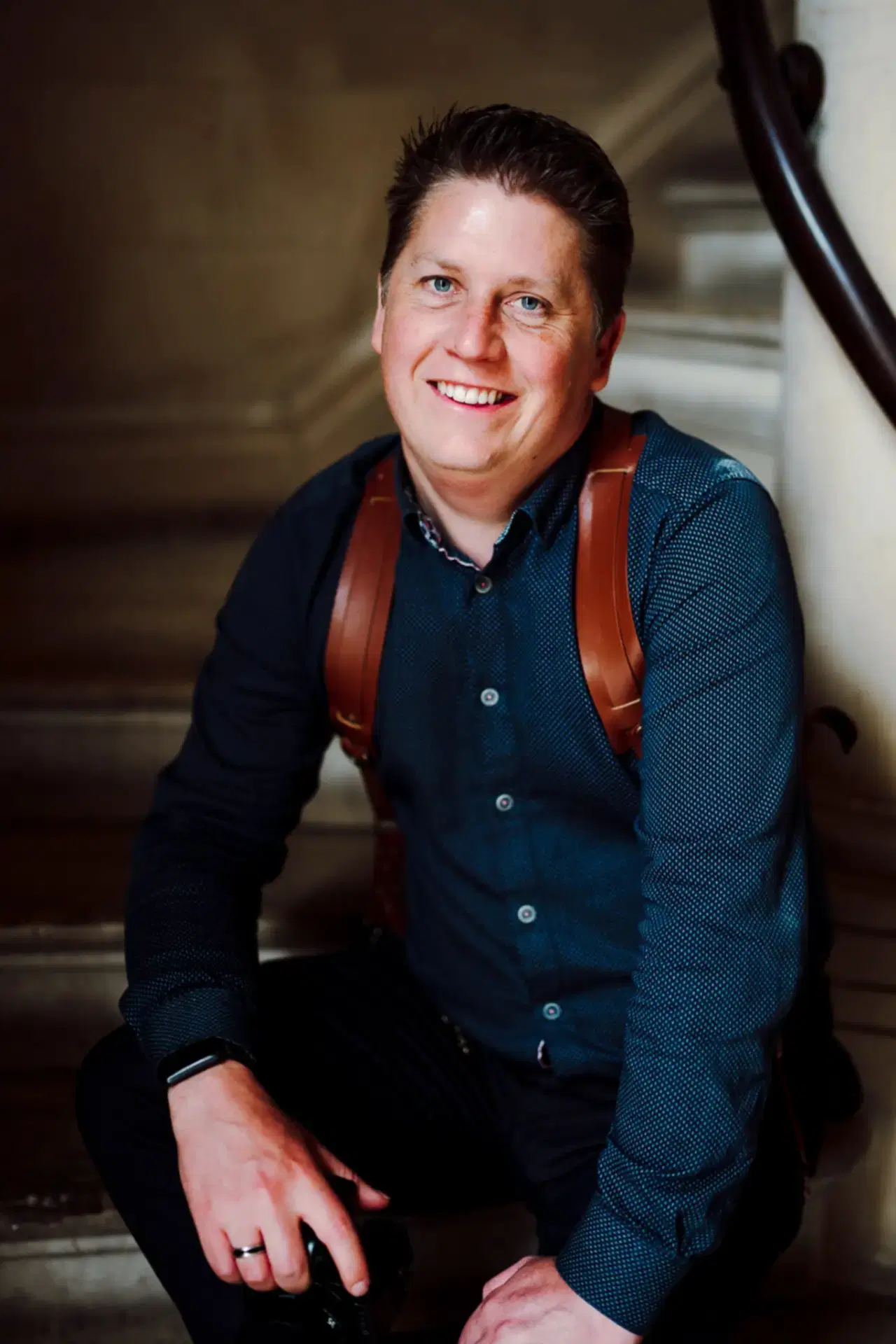 about white villa photo showing phil smiling and sat down with his camera on a stone staircase in this profile picture