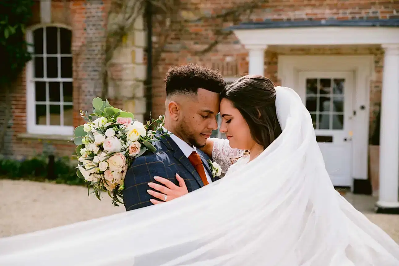 bride and groom surrounded by the brides veil as they embrace at Syrencot wedding venue