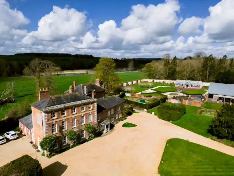 An FAQ section image showing Syrencot wedding venue taken from a drone on a sunny day
