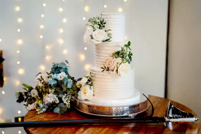 a wedding cake with sword on display at syrencot wedding venue in wiltshire