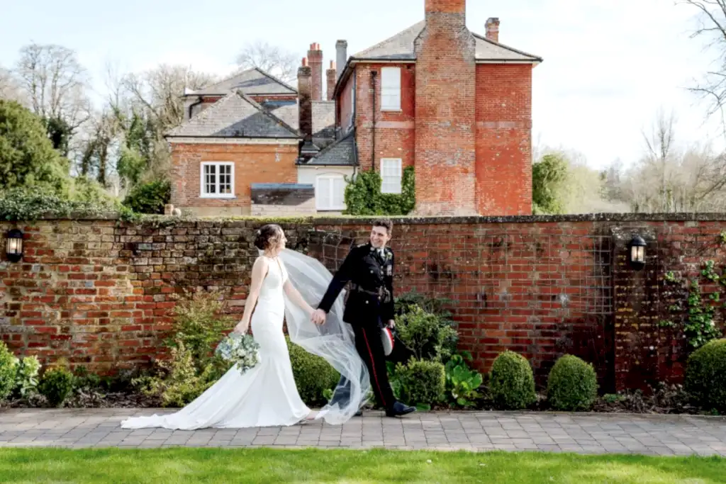 wiltshire-wedding-videographer-syrencot-uniform-holding-hands a groom in military uniform and bride holding hands while walking in a wiltshire wedding videographer photo