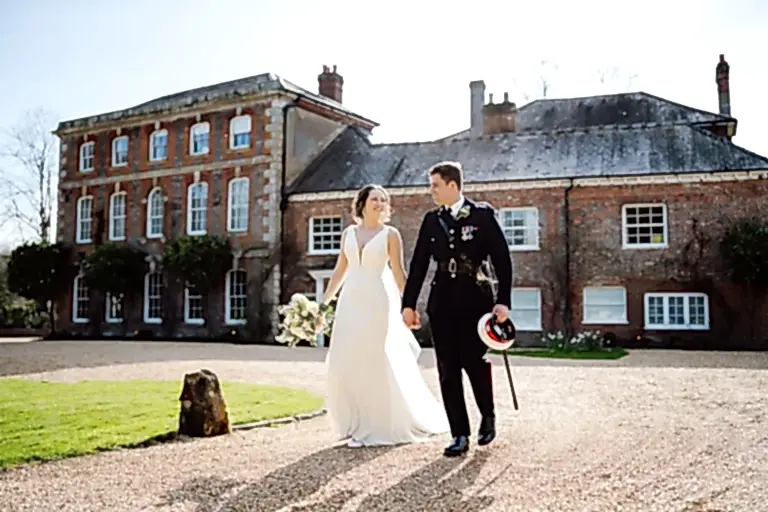 wedding couple walk holding hands outside Syrencot wedding venue in wiltshire