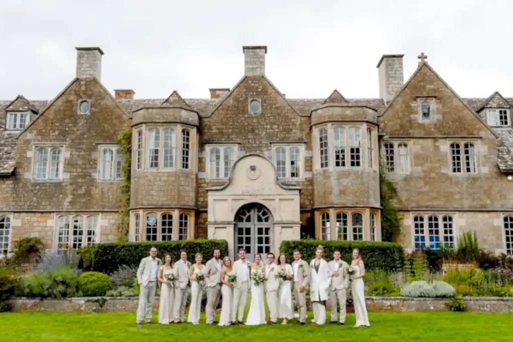 WAR0823-LOWRES-0950 bridal party pose in a line for their cotswold wedding videographer outside hilles house wedding venue