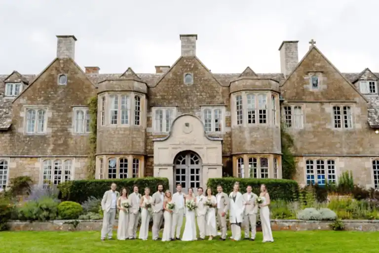 bridal party pose in a line for their cotswold wedding videographer outside hilles house wedding venue