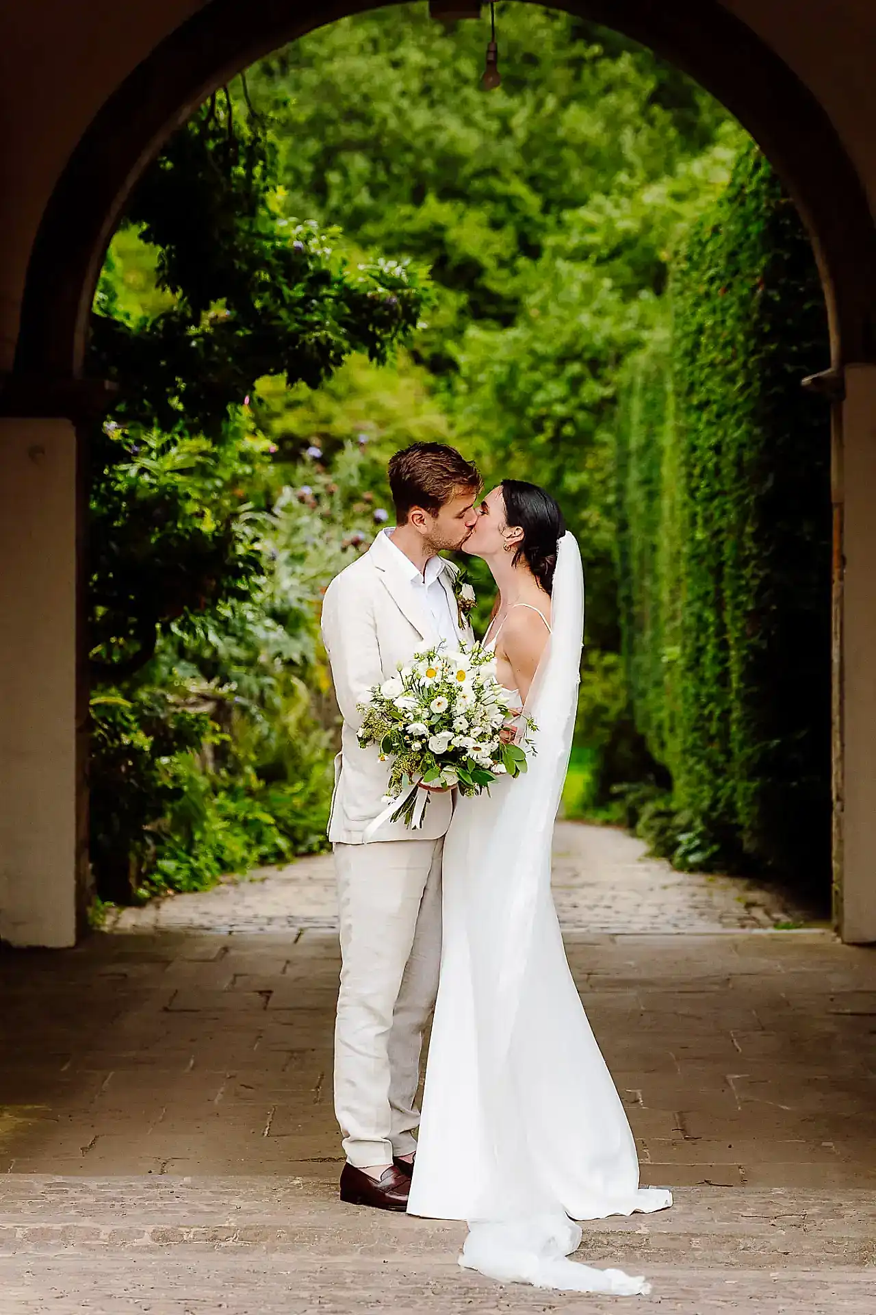 a bride and groom embrace and kiss for their cotswold wedding photographer