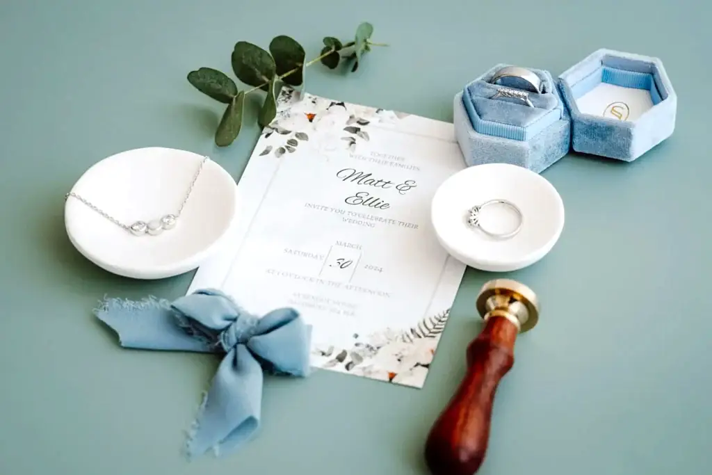 wedding-invite-rings-flatlay-detail an image showing wedding details including rings and necklace explaining how to contact us